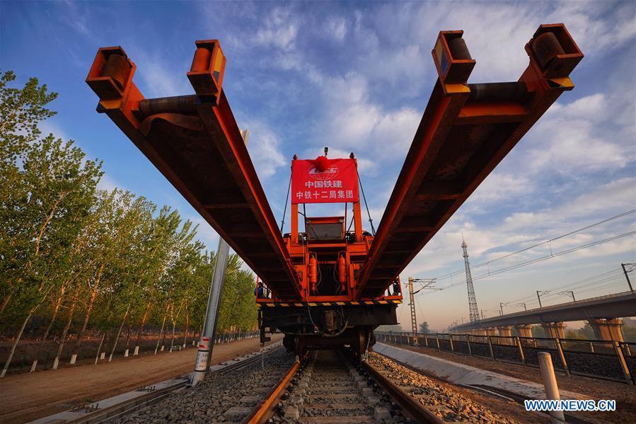 Builders of China Railway 12th Bureau Group operate machine to lay tracks at the construction site of the Liying section of the Beijing-Xiongan intercity railway, April 15, 2019. Track-laying work of the Beijing-Xiongan intercity railway began on Monday. (Xinhua/Xing Guangli)