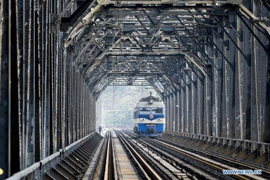 An electrical locomotive runs on the previous Baishatuo Yangtze River railway bridge in Jiangjin of southwest China\'s Chongqing Municipality, April 23, 2019. The previous Baishatuo Yangtze River railway bridge, completed in 1959, will stop service after April 24. All trains will run on the new double decker steel truss cable stay railway bridge after that day. The new bridge has 4 tracks on the upper deck for passenger trains with a designed speed of 200 kilometers per hour and 2 tracks on the lower deck for cargo trains with the designed speed of 120 kilometers per hour. (Xinhua/Liu Chan)