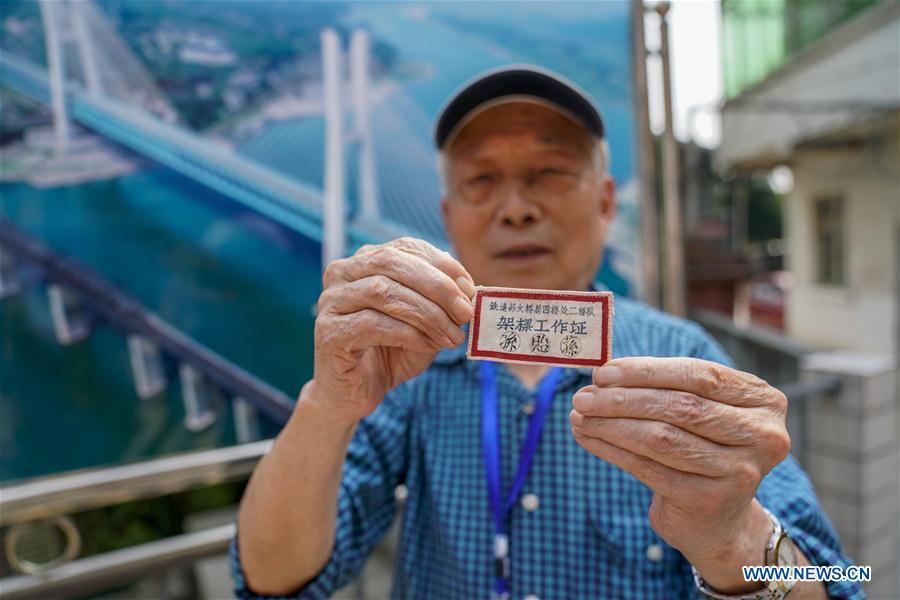 Sun Yisun, a former builder of the previous Baishatuo Yangtze River railway bridge, shows his old employee\'s card in Jiangjin of southwest China\'s Chongqing Municipality, April 23, 2019. The previous Baishatuo Yangtze River railway bridge, completed in 1959, will stop service after April 24. All trains will run on the new double decker steel truss cable stay railway bridge after that day. The new bridge has 4 tracks on the upper deck for passenger trains with a designed speed of 200 kilometers per hour and 2 tracks on the lower deck for cargo trains with the designed speed of 120 kilometers per hour. (Xinhua/Liu Chan)