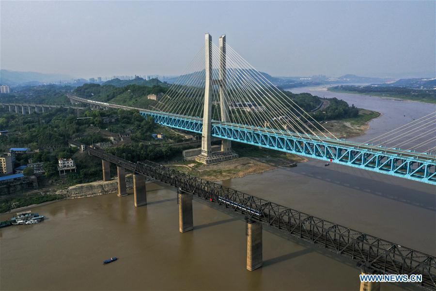 Aerial photo taken on April 23, 2019 shows the previous (L) and the new Baishatuo Yangtze River railway bridge in Jiangjin of southwest China\'s Chongqing Municipality. The previous Baishatuo Yangtze River railway bridge, completed in 1959, will stop service after April 24. All trains will run on the new double decker steel truss cable stay railway bridge after that day. The new bridge has 4 tracks on the upper deck for passenger trains with a designed speed of 200 kilometers per hour and 2 tracks on the lower deck for cargo trains with the designed speed of 120 kilometers per hour. (Xinhua/Liu Chan)