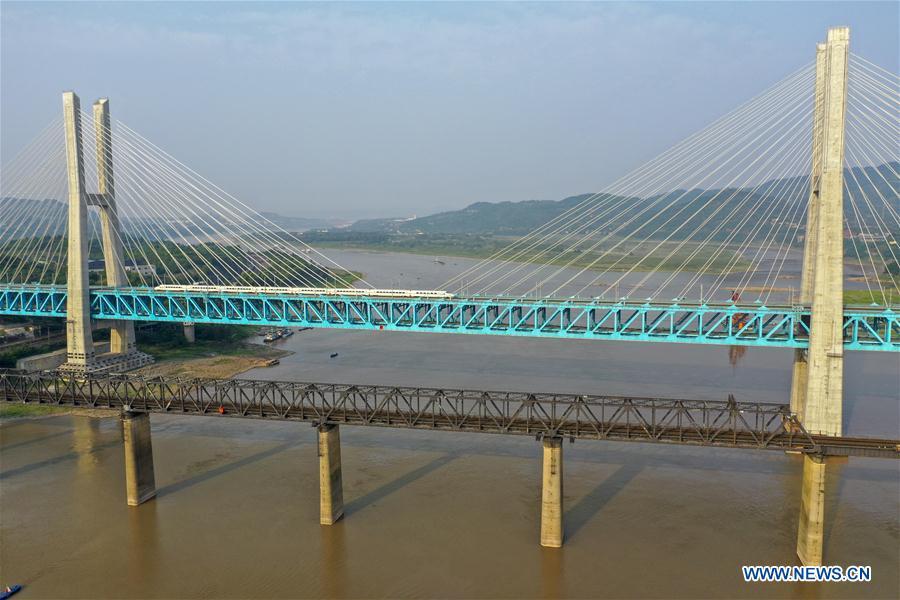 Aerial photo taken on April 23, 2019 shows a bullet train running on the new Baishatuo Yangtze River railway bridge (Back) in Jiangjin of southwest China\'s Chongqing Municipality. The previous Baishatuo Yangtze River railway bridge, completed in 1959, will stop service after April 24. All trains will run on the new double decker steel truss cable stay railway bridge after that day. The new bridge has 4 tracks on the upper deck for passenger trains with a designed speed of 200 kilometers per hour and 2 tracks on the lower deck for cargo trains with the designed speed of 120 kilometers per hour. (Xinhua/Liu Chan)