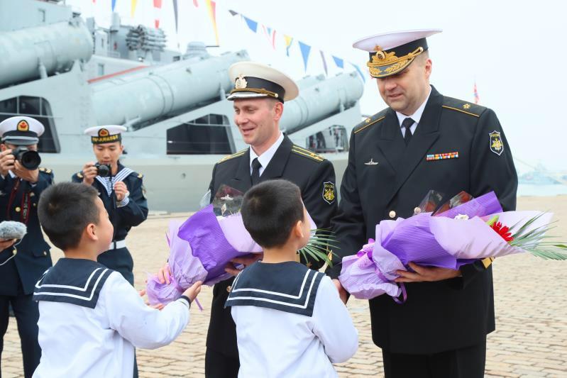 Russian navy officers receive flowers from Chinese children at Qingdao Port during a welcoming ceremony for Russian ships at the Sino-Russia Joint Sea 2019 naval exercise on Monday, April 29, 2019.  (Photo/China Plus)