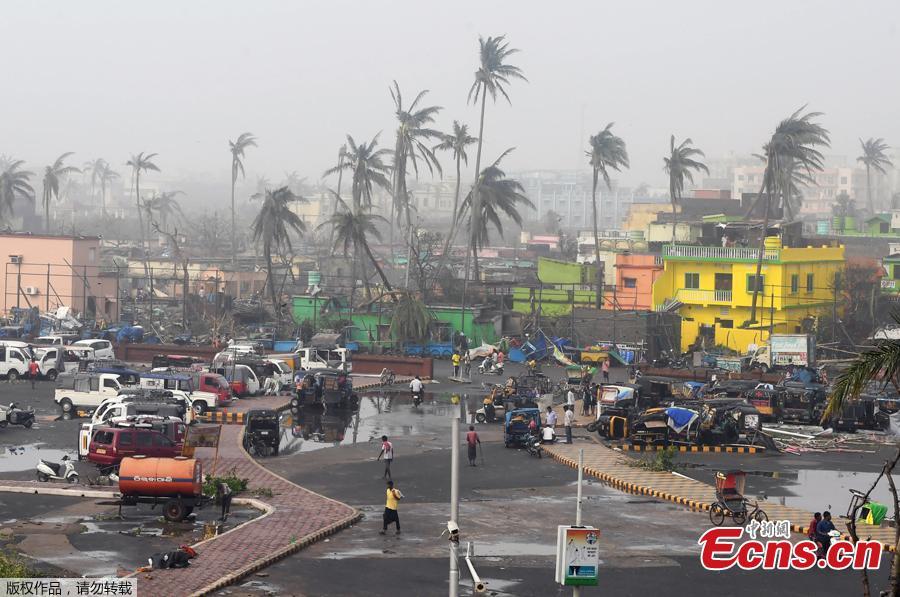 People gather next to storm-damaged buildings and palm trees in Puri in the eastern Indian state of Odisha on May 4, 2019, after Cyclone Fani swept through the area.  Cyclone Fani, one of the biggest to hit India in years, barrelled into Bangladesh on May 4 after leaving a trail of deadly destruction in India. (Photo/Agencies)
