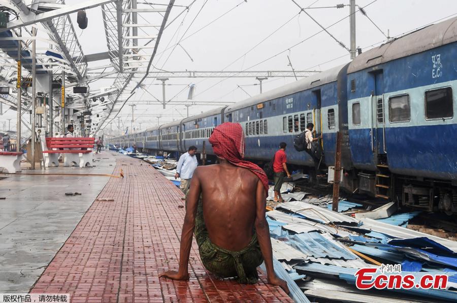 An Indian man sits on the train station platform as people look through debris on the tracks at the damaged railway station in Puri in the eastern Indian state of Odisha on May 4, 2019, after Cyclone Fani swept through the area.  Cyclone Fani, one of the biggest to hit India in years, barreled into Bangladesh on May 4 after leaving a trail of deadly destruction in India.  (Photo/Agencies)