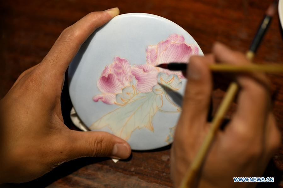 Ceramic painter Yang Yuhui paints in a studio in Shijiazhuang City, north China\'s Hebei province, May 27, 2019. (Xinhua/Xu Jianyuan)