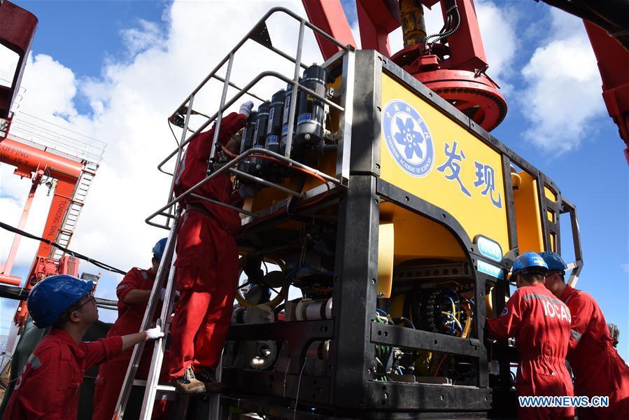 Members of the scientific expedition checks the remote operated vehicle (ROV), Discovery, before it dives into the sea in the south of the Mariana Trench, May 27, 2019. China\'s research vessel KEXUE (Science) on Monday started to explore a series of seamounts in the south of the Mariana Trench, the deepest place of the earth. The remote operated vehicle (ROV), Discovery, dived into the sea on Monday morning to collect videos, information and samples from a small seamount in the southwest of the targeted area. (Xinhua/Zhang Xudong)
