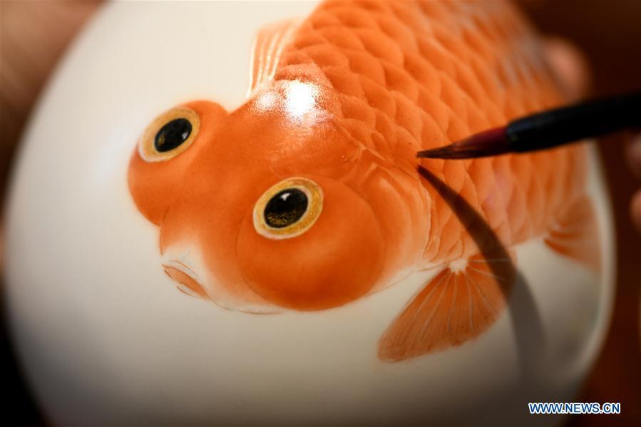 Ceramic painter Yang Yuhui paints in a studio in Shijiazhuang City, north China\'s Hebei province, May 27, 2019. (Xinhua/Xu Jianyuan)