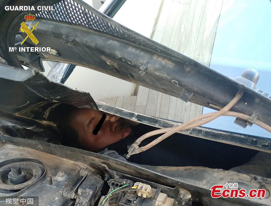 A picture shows a man in his twenties hiding behind the car\'s dashboard at the border in Beni-Enzar, Morocco. The refugee travelling from Morocco was found cramped into a car glove box attempting to travel to Europe. The car was stopped by border police whilst trying to enter Spain’s North African enclave of Melilla. Spanish Guard officers said three vehicles carrying stowaways were stopped in the space of three hours and found a total of four Moroccan migrants hidden in four vehicles. (Photo/VCG)