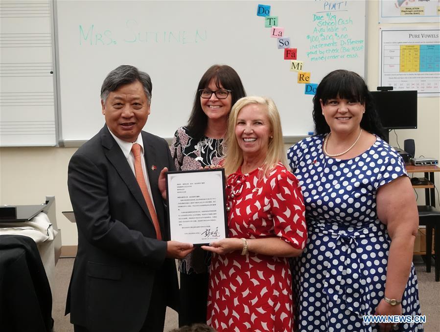 Li Qiangmin, Chinese consul general in Houston (1st L) delivers the letter from Peng Liyuan, wife of Chinese President Xi Jinping, to the faculties of Bak Middle School of the Arts in West Palm Beach, Florida, the United States, April 26, 2019. On April 7, 2017, Peng Liyuan, wife of Chinese President Xi Jinping paid a visit to the school at the invitation of U.S. First Lady Melania Trump, where they watched students perform and talked with them, initiating efforts to build a bridge of people-to-people exchanges between China and the school. Bak\'s School Board Chair Francine Manthy and Executive Director Susy Diaz from the school wrote Peng a letter recently to mark the second anniversary of her visit and again express their appreciation to the Chinese first lady. To their delight, Peng quickly replied. In the letter, Peng said that both China and the United States have a splendid culture, and it is a common wish to strengthen bilateral exchanges, especially among young people. (Xinhua/Liu Jie)