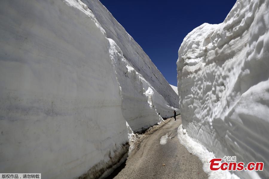 People take pictures on a road, surrounded by walls of snow, on May 28, 2019, in the northern Lebanese village of Ainata al-Arz, 1,620 meters above sea level.(Photo/Agencies)