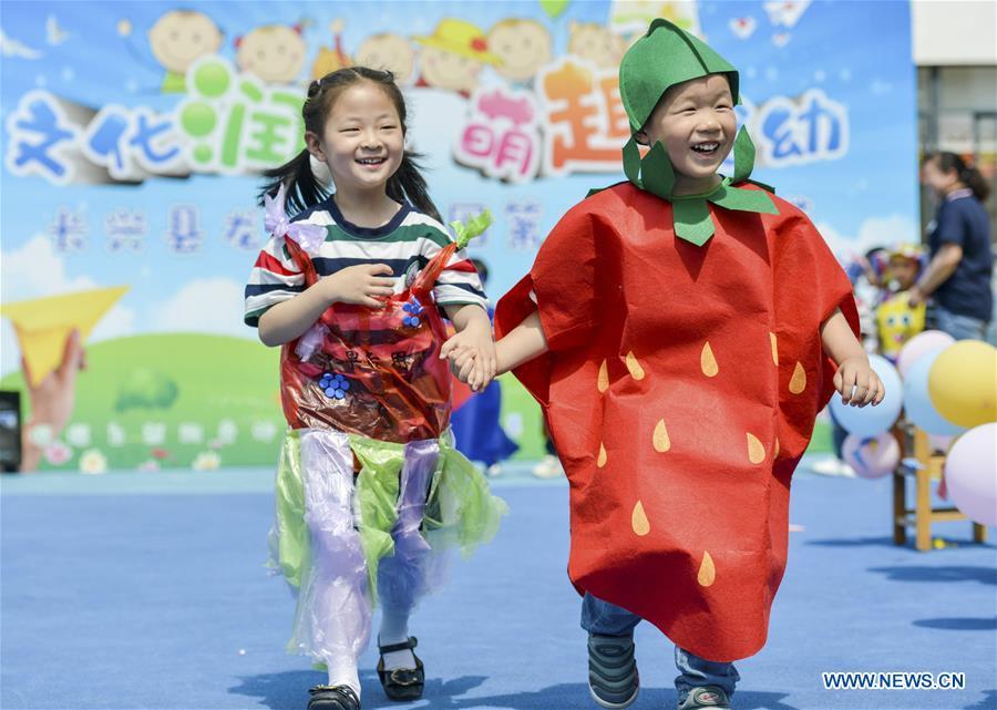Children show their handmade clothes during an activity to greet the upcoming International Children\'s Day at Longshan Kindergarten in Changxing County of Huzhou City, east China\'s Zhejiang Province, May 29, 2019. (Xinhua/Tan Yunfeng)