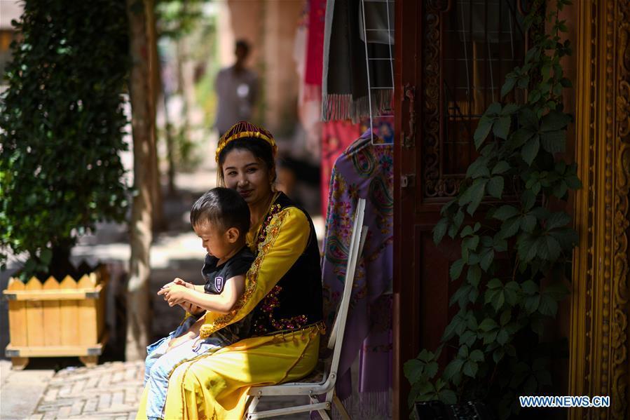 Local residents sit basking in the sunshine in the ancient city of Kashgar, northwest China\'s Xinjiang Uygur Autonomous Region, June 12, 2019. The ancient city of Kashgar has been well prepared for the peak tourism season through multiple measures including improving infrastructure and service quality as well as staging acrobatics performances to help tourists better experience the time-honored folk culture here. (Xinhua/Zhao Ge)