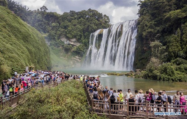 Tourists visit the Huangguoshu waterfall in Anshun City, southwest China's Guizhou Province, Oct. 2, 2017. From Oct. 1 to 8, the eight-day National Day and Mid-Autumn Festival holiday, around 710 million tourist trips will be made across China, according to predictions by China National Tourism Administration. (Xinhua/Chen Xi) Tourists visit the Huangguoshu waterfall in Anshun City, southwest China's Guizhou Province, Oct. 2, 2017. From Oct. 1 to 8, the eight-day National Day and Mid-Autumn Festival holiday, around 710 million tourist trips will be made across China, according to predictions by China National Tourism Administration. (Xinhua/Chen Xi)